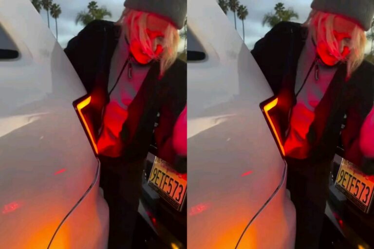 A woman tries to fix the Damage to another woman’s SUV Bumper by pounding on it after an accident